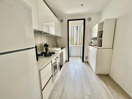 a kitchen with white appliances and a wooden floor at "Luxe Residence" Marsa avec Parking in Tunis