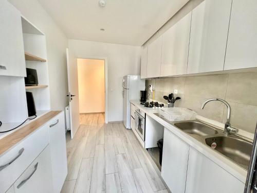 a kitchen with white cabinets and a sink at "Luxe Residence" Marsa avec Parking in Tunis