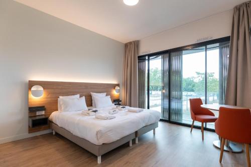 une chambre d'hôtel avec un lit, une table et des chaises dans l'établissement Villa Thermae Nancy, à Nancy