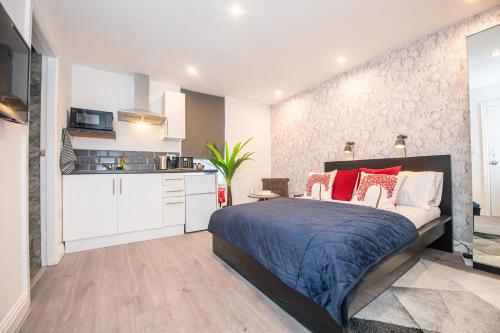 una camera con un grande letto e una cucina di The Blossoms Studio Apartments a Liverpool