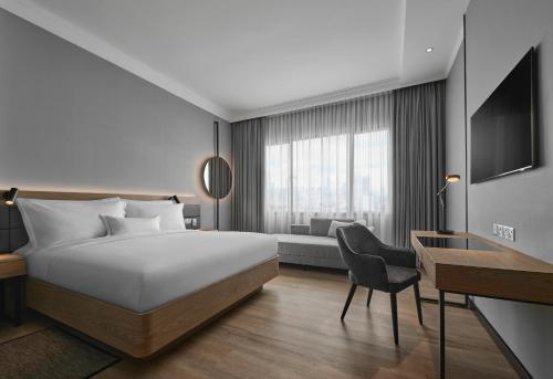 吉隆坡的住宿－AC Hotel by Marriott Kuala Lumpur，配有一张床和一张书桌的酒店客房