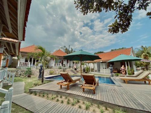 - une terrasse avec des chaises longues et des parasols à côté de la piscine dans l'établissement Blue Sky Villa Ceningan, à Nusa Lembongan