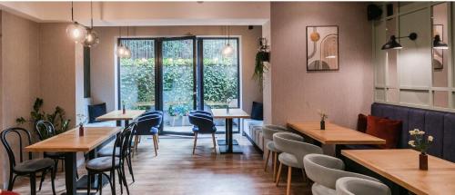 a restaurant with tables and chairs and a window at Hotel Vesper House in Gdańsk