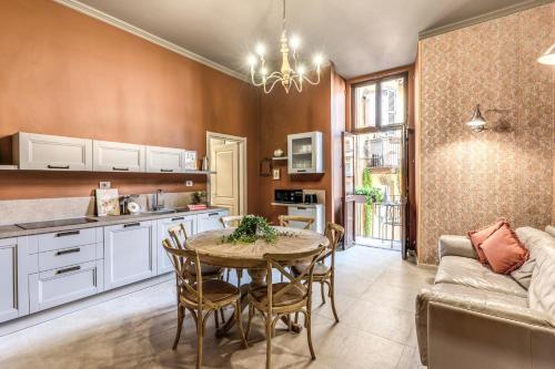 una cucina e una sala da pranzo con tavolo e divano di Corso Miracle Suite a Roma