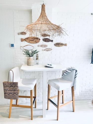 une salle à manger avec une table blanche et deux chaises dans l'établissement ELSK Cottage, à Zandvoort