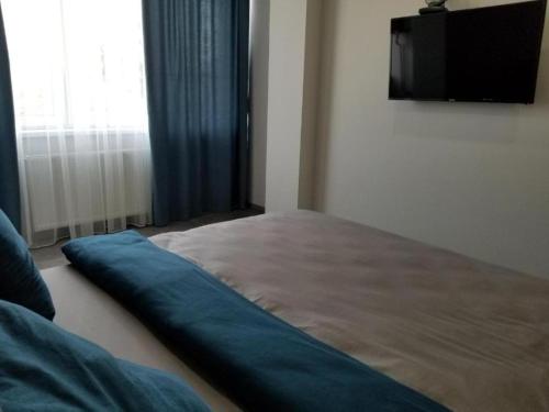 een slaapkamer met een bed en een flatscreen-tv bij Lux na Druhetiv in Oezjhorod