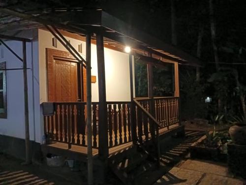 una pequeña casa con porche por la noche en Griya Sukatno, en Magelang