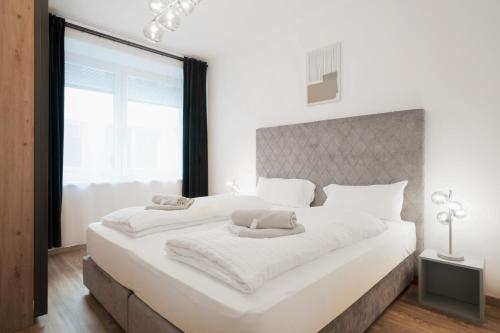 una camera da letto con un grande letto bianco con una grande finestra di easy flat Villach main plaza a Villach