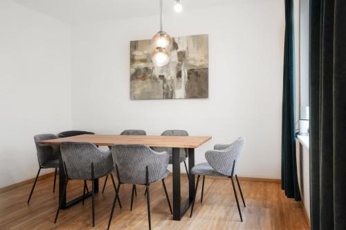 tavolo da pranzo con sedie e dipinto sul muro di easy flat Villach main plaza a Villach