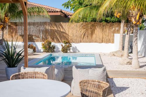 une terrasse avec une piscine, des chaises et une table dans l'établissement Appartement James, à Jan Thiel