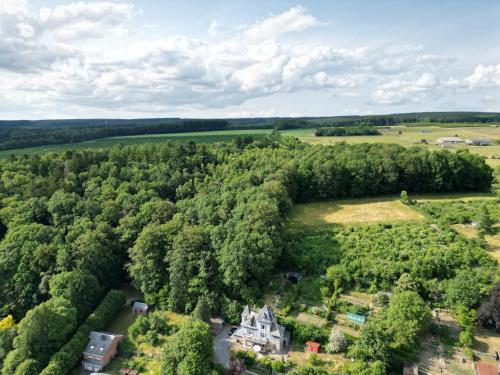 widok z powietrza na dom w środku lasu w obiekcie La Touratte Bed & Breakfast w mieście Saint-Hubert