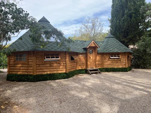 Cabaña de madera grande con techo de gambrel en La Vallée De Taradeau, en Taradeau