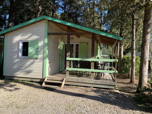 un pequeño cobertizo blanco con techo verde en La Vallée De Taradeau, en Taradeau