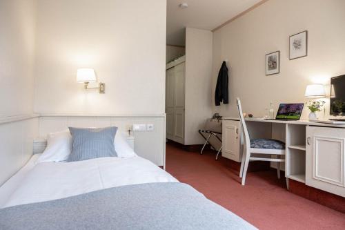 - une chambre avec un lit et un bureau avec un ordinateur dans l'établissement Hotel Ilmenautal inklusive THERMEplus, à Bad Bevensen