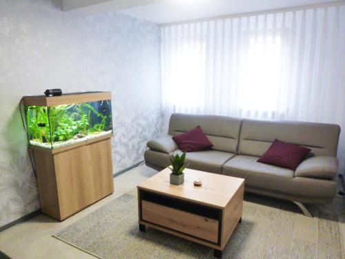 ein Wohnzimmer mit einem Sofa und einem Aquarium in der Unterkunft Ferienwohnung Familie Mergner in Bad Langensalza