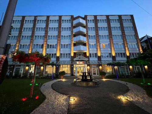 un grand bâtiment avec une fontaine devant lui dans l'établissement Best Western Plus Delta Park Hotel, à Mannheim