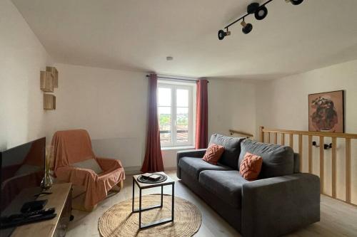 a living room with a couch and a window at Gîte NO 9 in Neufchâteau