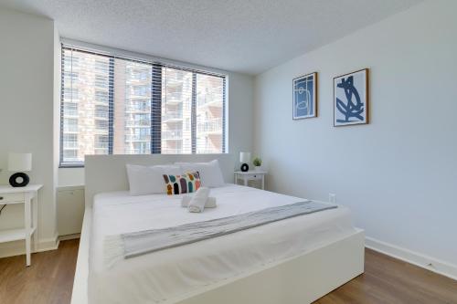 um quarto branco com uma grande cama branca e janelas em Unique Luxury Apt with Rooftop @Pentagon City em Arlington