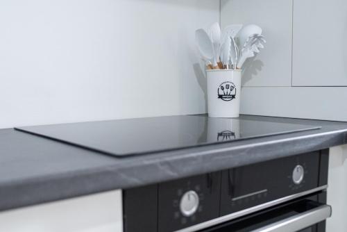 a kitchen counter with a cup of utensils at TEILOR Apartments 5 in Floreşti