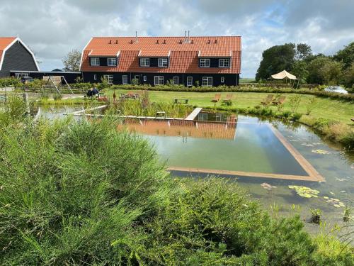 dom ze stawem przed budynkiem w obiekcie Nieuw Leven Texel w mieście Den Burg