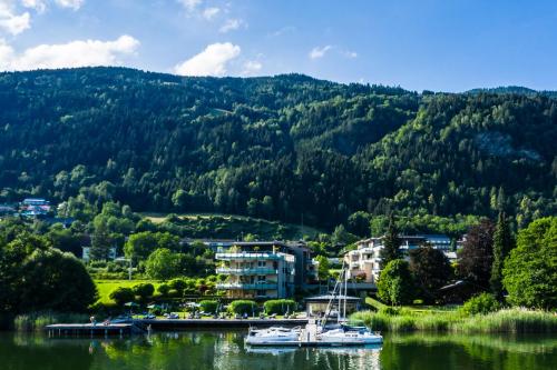 ein paar Boote auf einem See mit einem Berg in der Unterkunft Apart Hotel Legendär in Steindorf am Ossiacher See