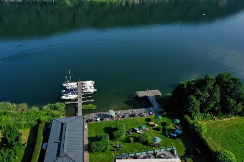 eine Luftansicht eines Docks mit einem Boot im Wasser in der Unterkunft Apart Hotel Legendär in Steindorf am Ossiacher See