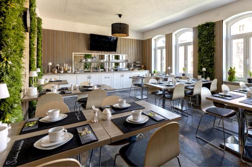 a restaurant with tables and chairs in a room at Hotel Garni " Am Domplatz" in Erfurt