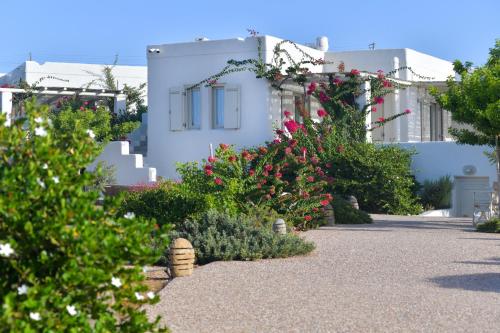 een tuin voor een wit gebouw met bloemen bij Portes Houses in Koufonisia