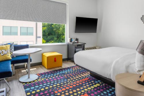 una camera d'albergo con letto, tavolo e TV di Aloft Nashville Airport a Nashville