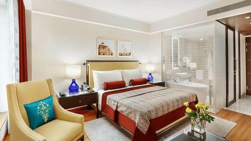 una camera d'albergo con letto e sedia di The Oberoi New Delhi a Nuova Delhi