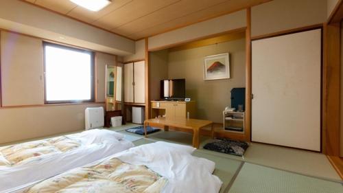 Onomichi Kokusai Hotel في أونوميتشي: غرفة نوم بسرير ومكتب ونافذة