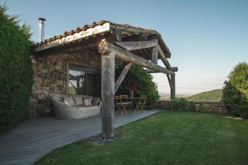 ein Steinhaus mit einer Pergola im Hof in der Unterkunft La Chomotte in Saint-Alban-dʼAy