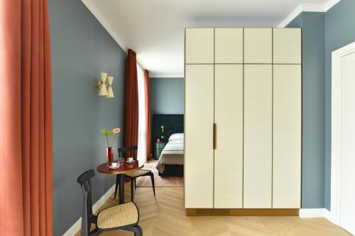 a room with a white cabinet and a table and a bed at Casa Brivio in Milan