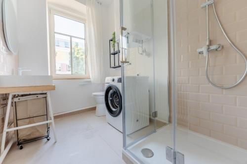 a bathroom with a washing machine in a shower at Gran.Suite - Central Station in Sankt Pölten