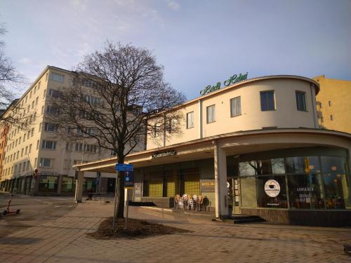 un edificio su una strada con un albero di fronte di Hotelli Helmi a Turku