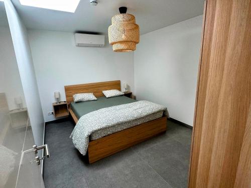 een kleine slaapkamer met een bed en een licht bij Akuta City Flat Leuven in Leuven