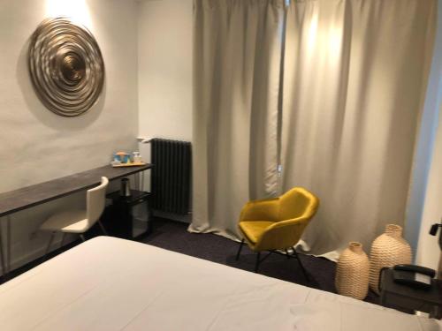 een slaapkamer met een bed en een gele stoel bij Best Western ARThotel in Le Havre