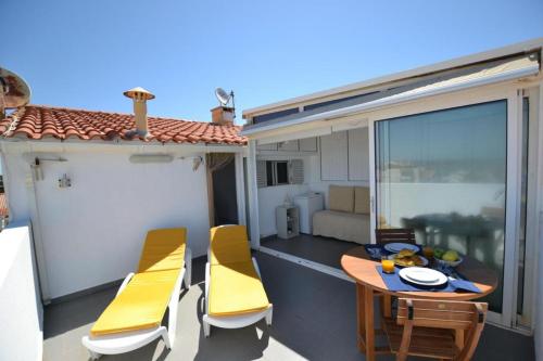 um pátio com uma mesa e cadeiras numa varanda em Ria Beach Studio em Faro