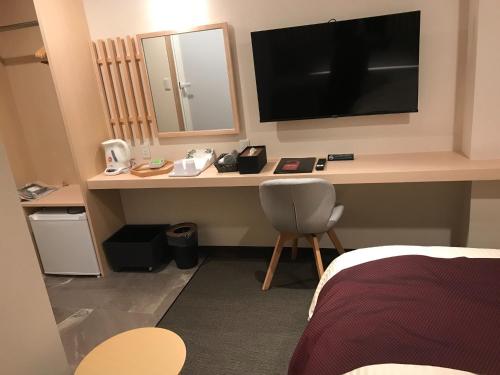 Pokój z biurkiem, telewizorem i krzesłem w obiekcie Aizu Tsuruya Hotel - Vacation STAY 57226v w mieście Aizu-Wakamatsu