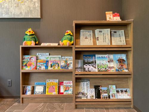 una estantería llena de libros y animales de peluche en Hotel Route Inn Kato, en Kato