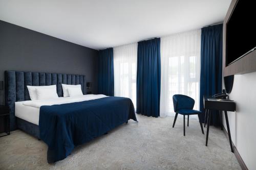 une chambre d'hôtel avec un lit et une chaise dans l'établissement Focus Hotel Premium Lublin, à Lublin