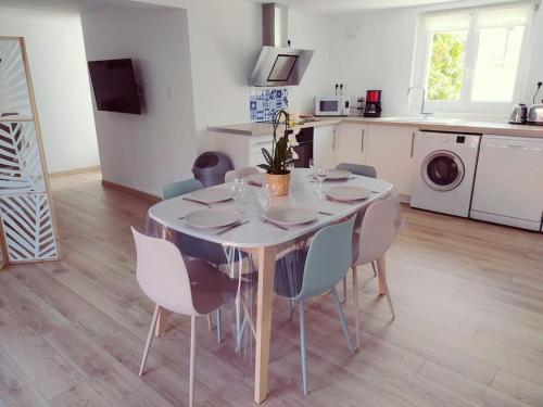 einen Esstisch mit Stühlen und eine Küche in der Unterkunft T3 - Appartement jardin Wissant 6 personnes in Wissant