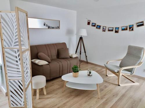 ein Wohnzimmer mit einem Sofa, einem Tisch und Stühlen in der Unterkunft T3 - Appartement jardin Wissant 6 personnes in Wissant