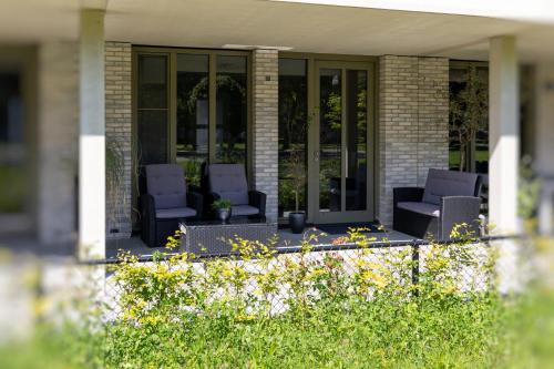 une terrasse couverte avec 2 chaises sur une maison dans l'établissement Luxury room with king size bed, à Dordrecht