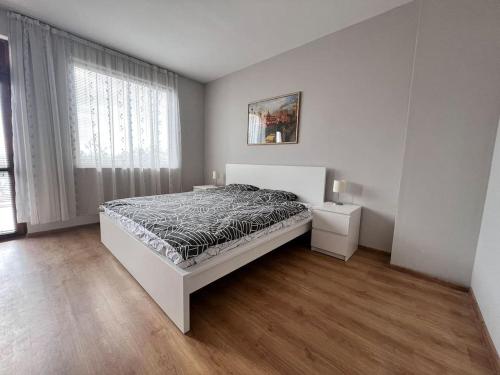 Habitación blanca con cama y ventana en Къща Каменар, en Pomorie