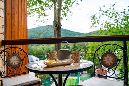 uma mesa com copos e uma tigela de comida numa varanda em Parádka - Toscana Villa em Parád