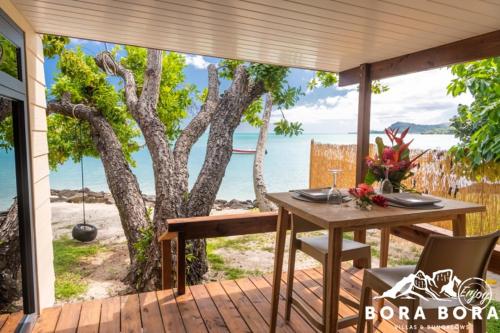 - une table et des chaises sur une terrasse avec vue sur l'océan dans l'établissement Matira Beach Raitea 2, à Bora Bora