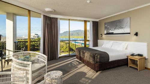 um quarto de hotel com uma cama e uma varanda em Pacific Hotel Cairns em Cairns