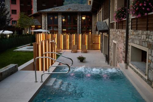 - une piscine dans une cour à côté d'un bâtiment dans l'établissement Blu Hotel Acquaseria, à Ponte di Legno