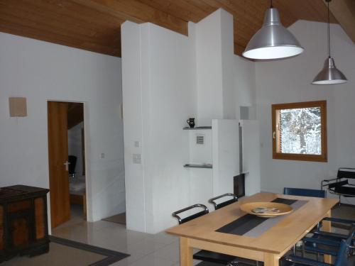 cocina con mesa de madera y nevera en Moderne attraktive Dachwohnung für max. 6 Personen in ruhiger Umgebung, en Flims